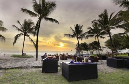 Sunset at The Royal Beach Seminyak Bali, MGallery Collection. Gay-friendly hotel with beachside dining, palm trees, and relaxed atmosphere.