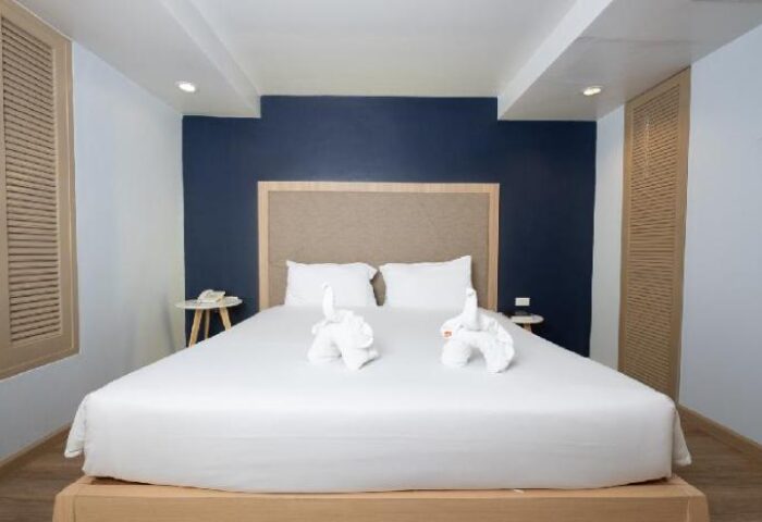 The Royal Palm Beachfront Hotel gay-friendly room. King bed with swan towels, blue accent wall. A great choice for gay travelers.