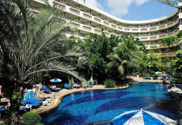 The Royal Paradise Hotel & Spa pool. Gay-friendly hotel in Thailand with a large pool, palm trees, and sun loungers. Perfect for gay travel.
