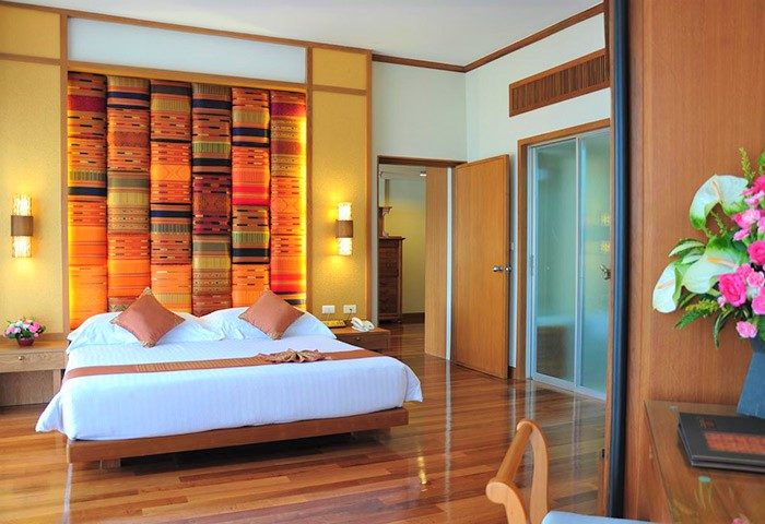 Gay-friendly The Royal Paradise Hotel & Spa bedroom. Room with double bed, colorful headboard, wood floor, and ensuite. Luxury gay travel.