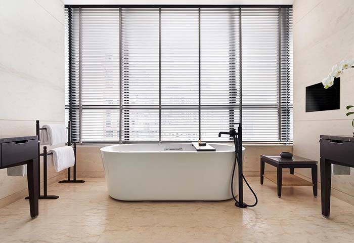 Bathroom at The RuMa Hotel and Residences, a gay-friendly hotel. Features a standalone tub, large window, & modern fixtures. Ideal for gay travelers.