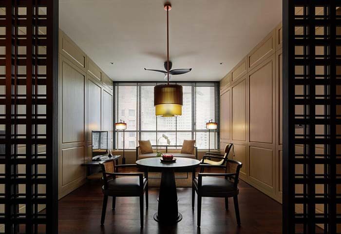 The RuMa Hotel and Residences room. Gay-friendly hotel with stylish decor, a round table, and comfortable seating. Modern design elements.