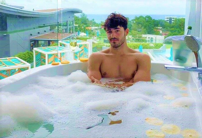 Gay-Friendly Hotel: Man relaxing in a bubble bath at The SIS Kata Resort. Luxury travel for gay men in Thailand. Vacation goals.