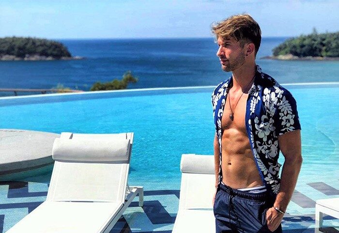 Gay-friendly The SIS Kata Resort: Man at infinity pool overlooking the ocean. Ideal gay travel destination in Phuket, Thailand.