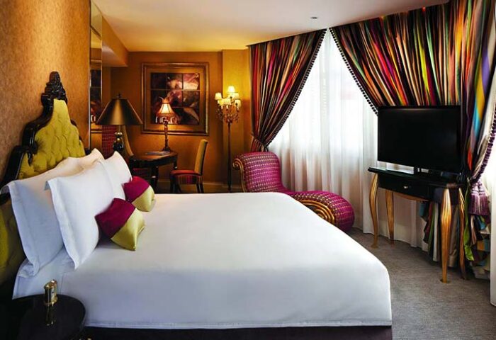 The Scarlet Singapore Hotel room. Gay-friendly hotel with luxury bedding, colorful curtains, and stylish furniture. Singapore gay travel.