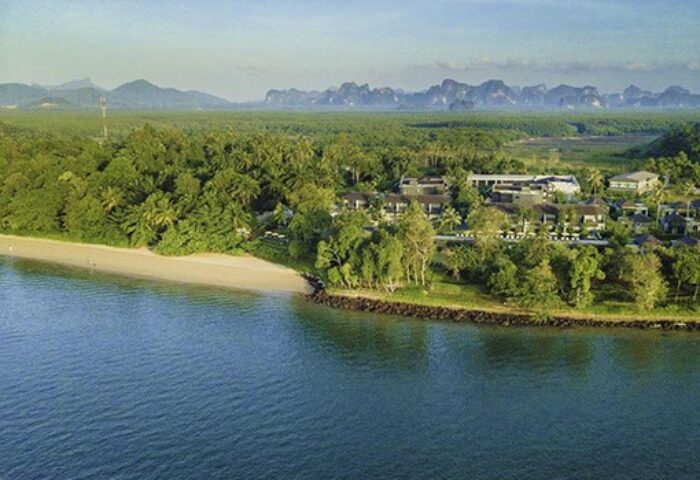 The Shell Sea Krabi: Gay-friendly hotel aerial view. Beachfront resort nestled among lush greenery, mountains in the distance. Perfect gay getaway.