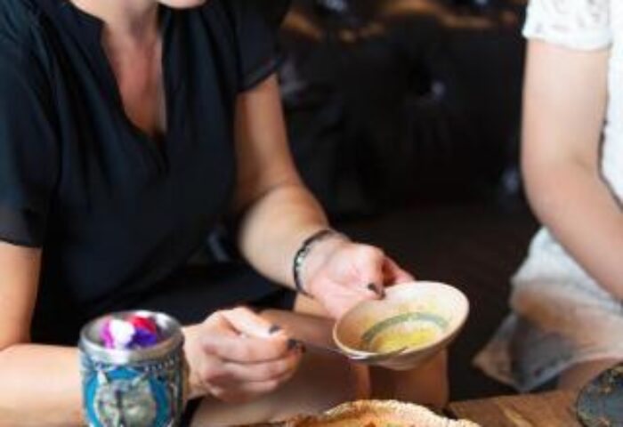 Dining at The Sheung Wan, a gay-friendly hotel. Woman enjoys food and drinks. Hong Kong travel for gay men.