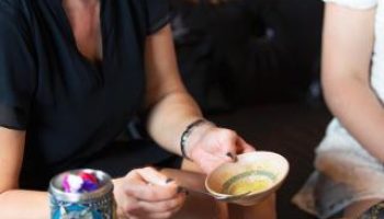 Dining at The Sheung Wan, a gay-friendly hotel. Woman enjoys food and drinks. Hong Kong travel for gay men.