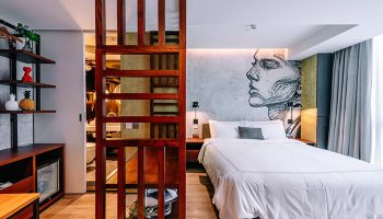 The Sheung Wan hotel room. Modern design with a bed, wooden screen, and artistic wall mural. Gay-friendly hotel in Sheung Wan, Hong Kong.