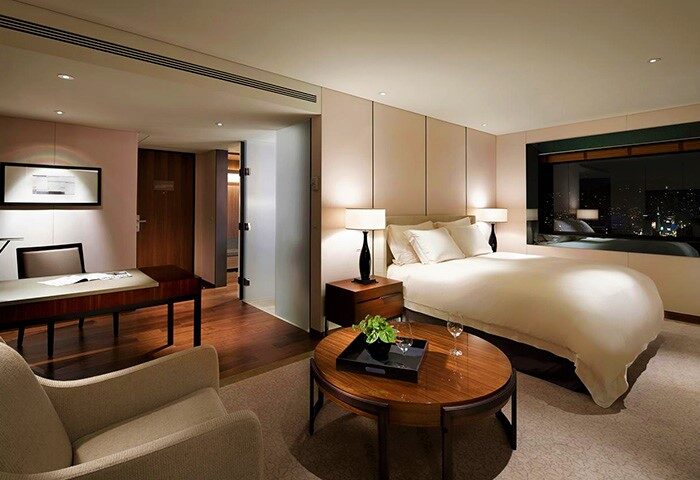 The Shilla Seoul gay-friendly hotel room. Luxury interior with a bed, desk, and city view. Ideal for gay men's travel in Seoul, South Korea.