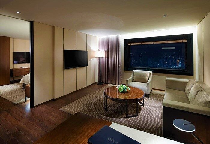 The Shilla Seoul hotel room. Gay-friendly travel lodging with a city view, sofa, chair, and TV for a relaxing stay. Modern design.