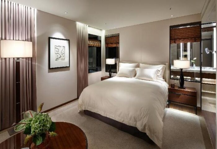 The Shilla Seoul gay-friendly hotel room. Luxurious bedroom with king bed, bedside tables, lamps, and art. Upscale gay travel in Seoul.
