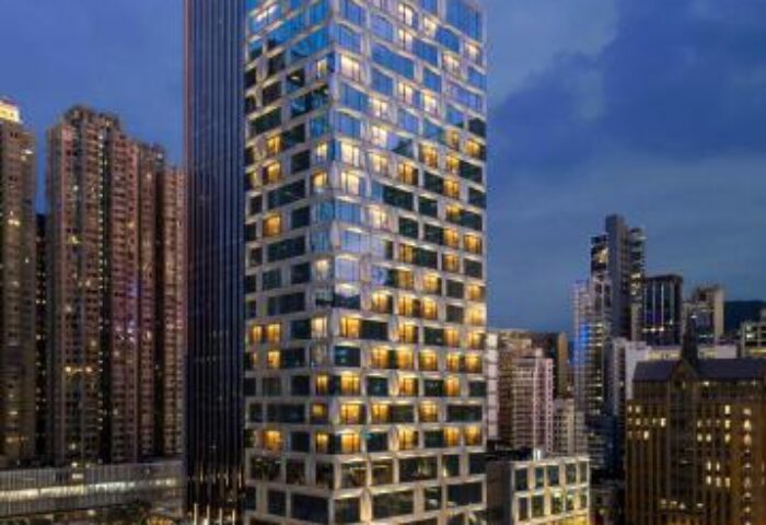 The St. Regis Hong Kong, a gay-friendly hotel. Exterior view of the modern building at night, showcasing its illuminated windows and urban setting.