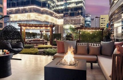 The St. Regis Mexico City gay-friendly hotel patio. Fire pit, hanging chair, and dining area with city views. Luxury travel for gay men.