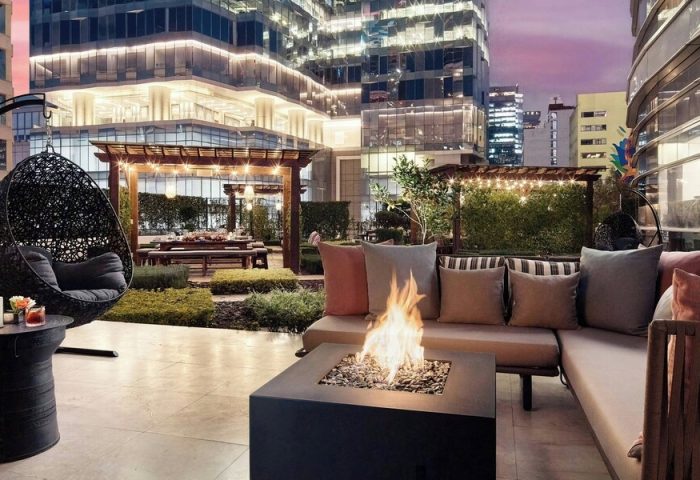 The St. Regis Mexico City gay-friendly hotel patio. Fire pit, hanging chair, and dining area with city views. Luxury travel for gay men.