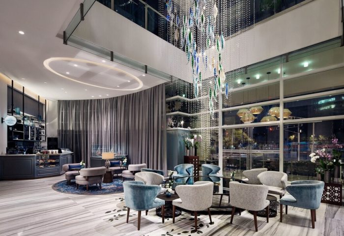 The St. Regis Mexico City's lobby lounge. Gay-friendly hotel with luxury seating, a chandelier, and floor-to-ceiling windows. Upscale design.