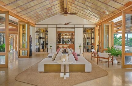 Interior of The St. Regis Punta Mita Resort, a gay-friendly hotel. Open space with seating, shelves, and a high ceiling.