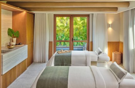 Gay-friendly hotel The St. Regis Punta Mita Resort spa. Two massage beds face a window with lush green view. Relaxing retreat.
