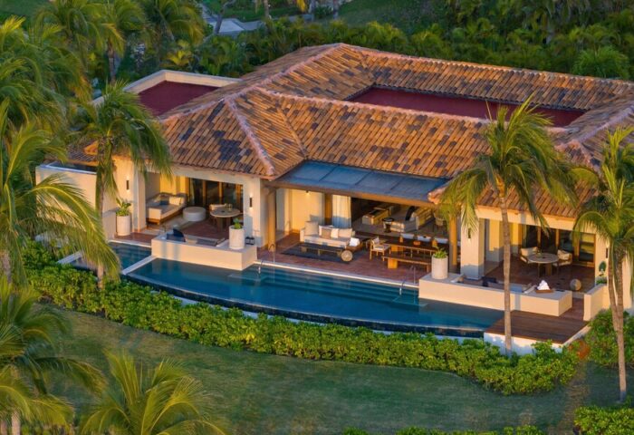 The St. Regis Punta Mita Resort's gay-friendly hotel. Aerial view of a luxury villa with a pool, patio, and palm trees. Ideal for gay travel.