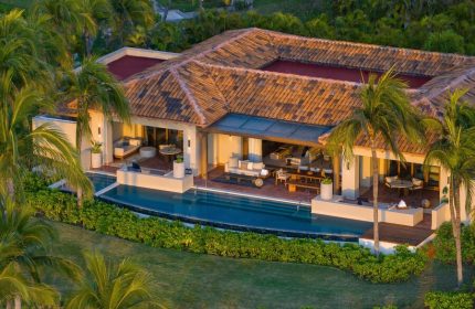 The St. Regis Punta Mita Resort's gay-friendly hotel. Aerial view of a luxury villa with a pool, patio, and palm trees. Ideal for gay travel.