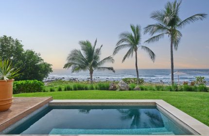 Gay-friendly hotel The St. Regis Punta Mita Resort view. Pool, palm trees, and ocean view. Luxury travel for gay men.