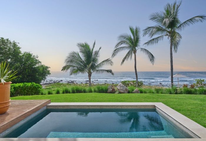 Gay-friendly hotel The St. Regis Punta Mita Resort view. Pool, palm trees, and ocean view. Luxury travel for gay men.