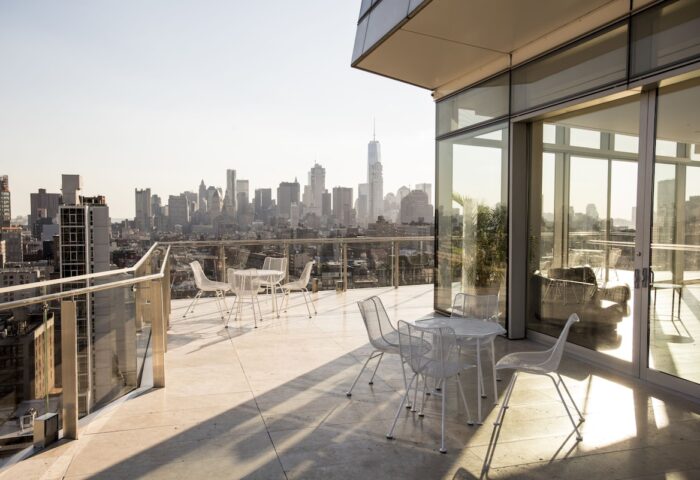 The Standard East Village gay-friendly hotel balcony view. New York City skyline with tables and chairs. Great spot for gay travelers.