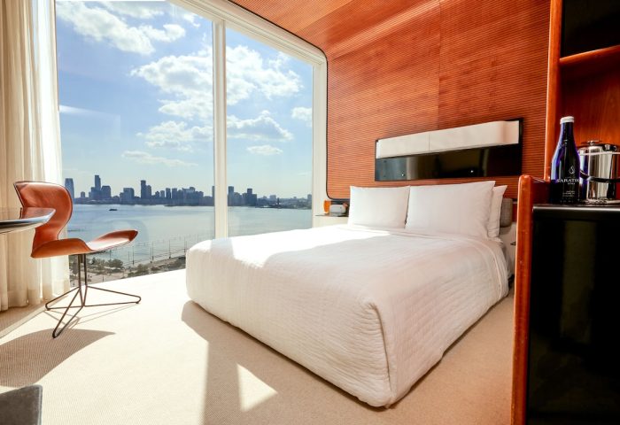 The Standard High Line New York hotel room. Gay-friendly hotel with skyline view. Modern design, white bedding, and Hudson River view.