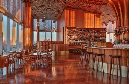 Bar interior at The Standard, High Line, New York. Gay-friendly hotel with city views, bar stools, and a fully stocked bar.