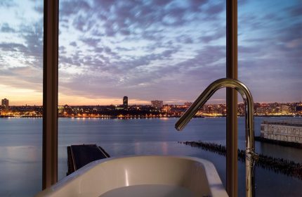 The Standard High Line New York, a gay-friendly hotel. Bathtub with city view at sunset. Luxury travel for gay men.