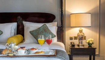 The Strand Yangon gay-friendly hotel room service. Breakfast in bed with juice, pastries, and fruit. Luxury travel in Yangon, Myanmar.