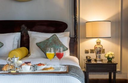 The Strand Yangon gay-friendly hotel room service. Breakfast in bed with juice, pastries, and fruit. Luxury travel in Yangon, Myanmar.