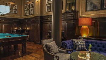 The Strand Yangon gay-friendly hotel: Billiard room with pool table, sofa, and chairs. A luxurious space for travelers in Yangon, Myanmar.