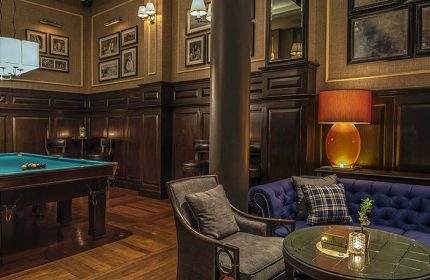 The Strand Yangon gay-friendly hotel: Billiard room with pool table, sofa, and chairs. A luxurious space for travelers in Yangon, Myanmar.