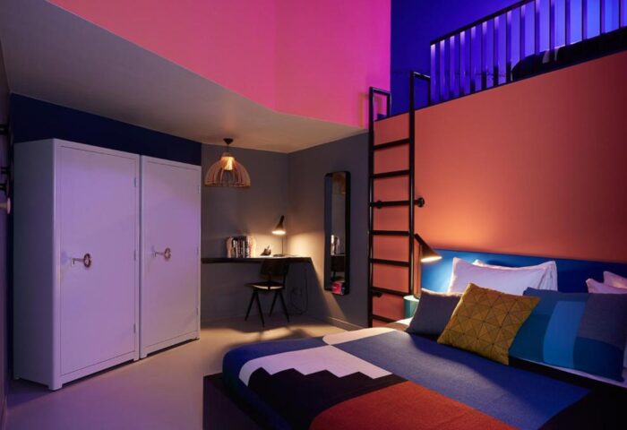 Gay-friendly The Student Hotel Amsterdam City room. Colorful modern design with bed, desk, wardrobe, and ladder to loft.