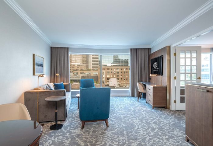 The Sutton Place Hotel Vancouver suite. Gay-friendly hotel room with city view, sofa, desk, and modern decor. Ideal for gay travel in Vancouver.