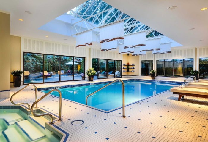 Indoor pool at The Sutton Place Hotel Vancouver, a gay-friendly hotel. Bright, with skylight, lounge chairs, and jacuzzi. Relaxing vacation.