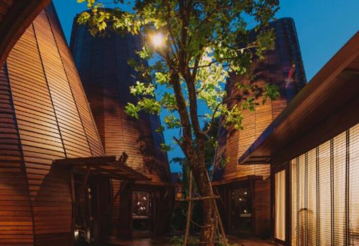 The Tubkaak Krabi Boutique Resort architecture at night. Gay-friendly hotel with wooden buildings and a tree in the center. Krabi, Thailand.
