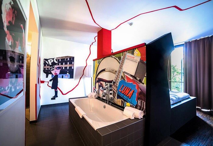 Weinmeister Berlin-Mitte Adults Only hotel, gay-friendly, pet-friendly. Room view: bathtub, modern art, and bed. Unique design hotel.