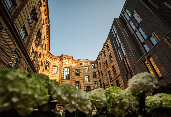 The Weinmeister Berlin-Mitte Adults Only hotel exterior. Gay-friendly, pet-friendly hotel architecture in Berlin, Germany. Flowers in foreground.