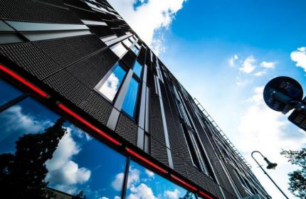 The Weinmeister Berlin-Mitte, adults-only, pet-friendly, gay-friendly hotel. Exterior view of the building with a modern design and blue sky.