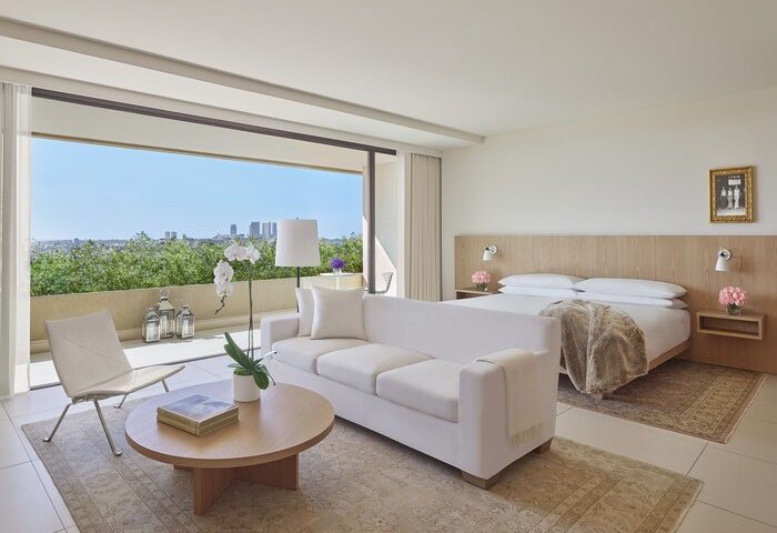 West Hollywood EDITION gay-friendly hotel suite. Balcony view, white sofa, and king bed. Upscale travel for gay men in West Hollywood.