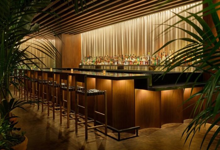 Bar at The West Hollywood EDITION, a gay-friendly hotel. Stylish interior with stools, plants, and a well-stocked bar for gay travelers.