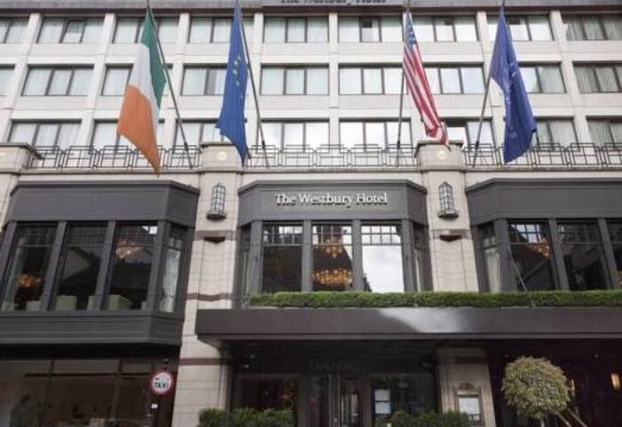 Facade of The Westbury Hotel, a gay-friendly hotel in Dublin. Flags of Ireland, the EU, and the USA are displayed. Luxury gay travel.