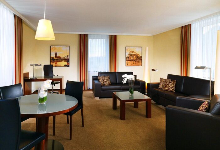 The Westin Grand Frankfurt gay-friendly hotel room. Leather sofas, desk, and table. Upscale, welcoming space for gay travelers.