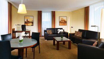 The Westin Grand Frankfurt gay-friendly hotel room. Leather sofas, desk, and table. Upscale, welcoming space for gay travelers.