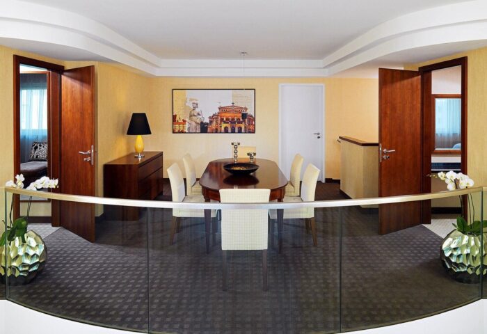 The Westin Grand Frankfurt gay-friendly hotel suite. Dining area with table, chairs, and modern decor. Upscale lodging for gay travelers.