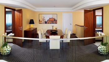 The Westin Grand Frankfurt gay-friendly hotel suite. Dining area with table, chairs, and modern decor. Upscale lodging for gay travelers.
