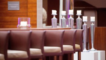The Westin Grand Frankfurt gay-friendly hotel decor. Candles on silver stands, brown leather chairs, and wood paneling create a warm ambiance.