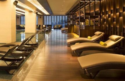 The Westin Jakarta gay-friendly hotel's pool area. Lounge chairs line the pool. Wood floors and modern decor. Great for gay travel.